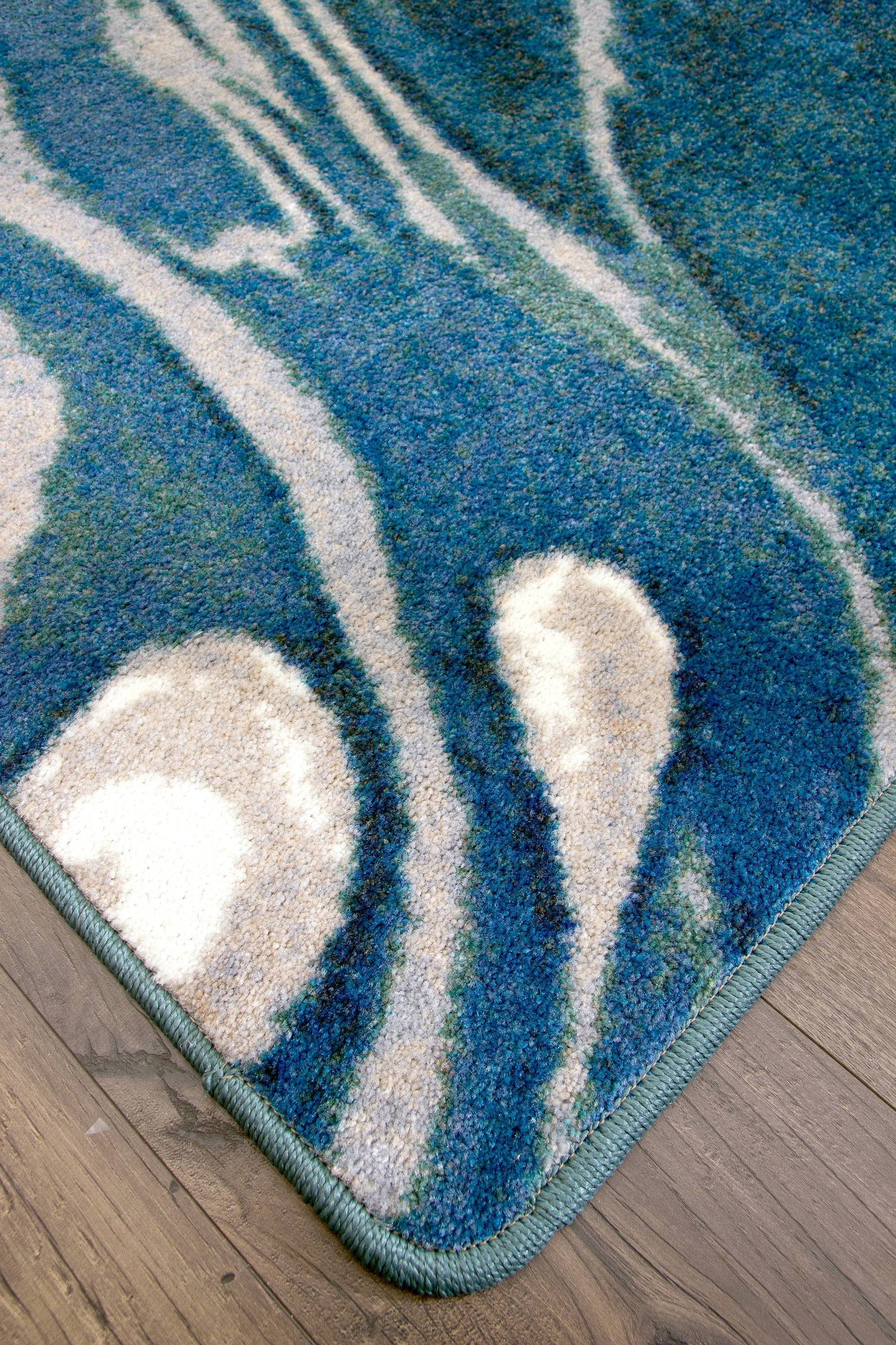 Corner view of Abstract Jellyfish - Ocean Blue coastal area rug. 